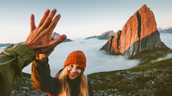 Planinarka s ispruženom rukom daje "pet" planinaru.