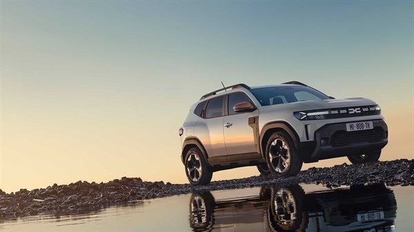 Vozilo Dacia Duster u varijanti 4x4 snimljeno na stjenovitom terenu uz vodu u zlatnom satu