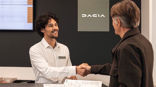 Klijent razgovara sa zaposlenikom Dacije za pultom u salonu.