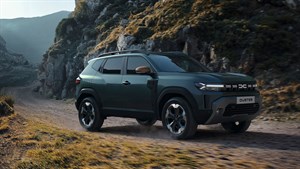 Vozilo Dacia Duster u vožnji planinskom cestom u prirodnom krajoliku.