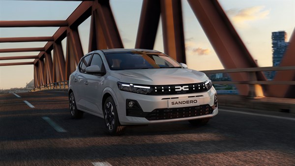 Vozilo Dacia Sandero u vožnji preko mosta u večernjem ambijentu.
