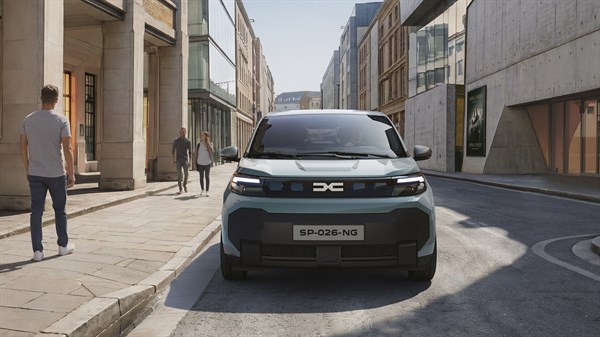 Vozilo Dacia Sandero Stepway u zlatno-žutoj boji, parkirano na otvorenom prostoru ispred stjenovitog krajolika po sunčanom vremenu.
