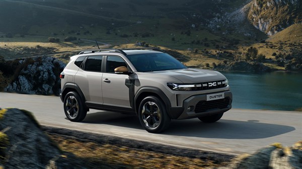 Vozilo Dacia Duster u vožnji planinskom cestom uz jezero.