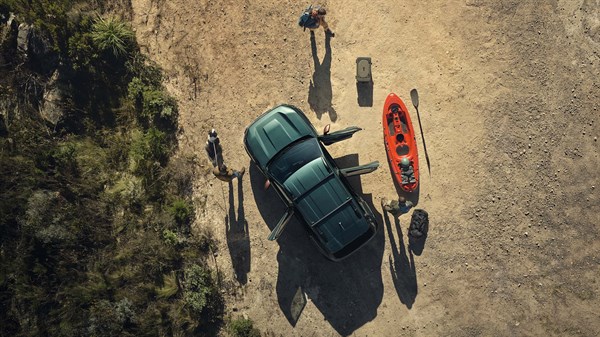 Dacia s opremom za aktivnosti na otvorenom, snimljena odozgo u prirodi uz kajak i drugu opremu.
