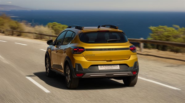 Dacia Sandero Stepway s krovnim nosačima vozi obalnom cestom uz more.