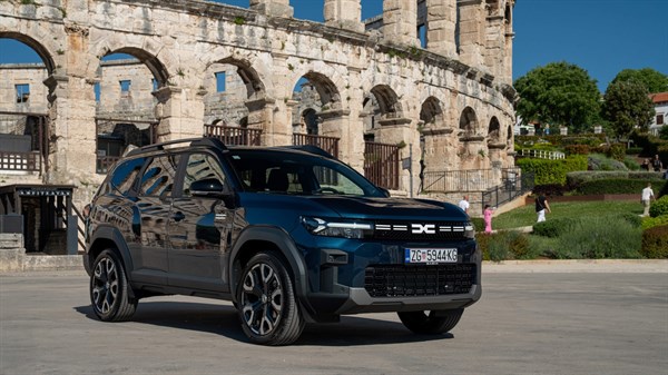 Tamnoplavi Dacia Bigster parkiran ispred rimskog amfiteatra u Puli za sunčanog dana.