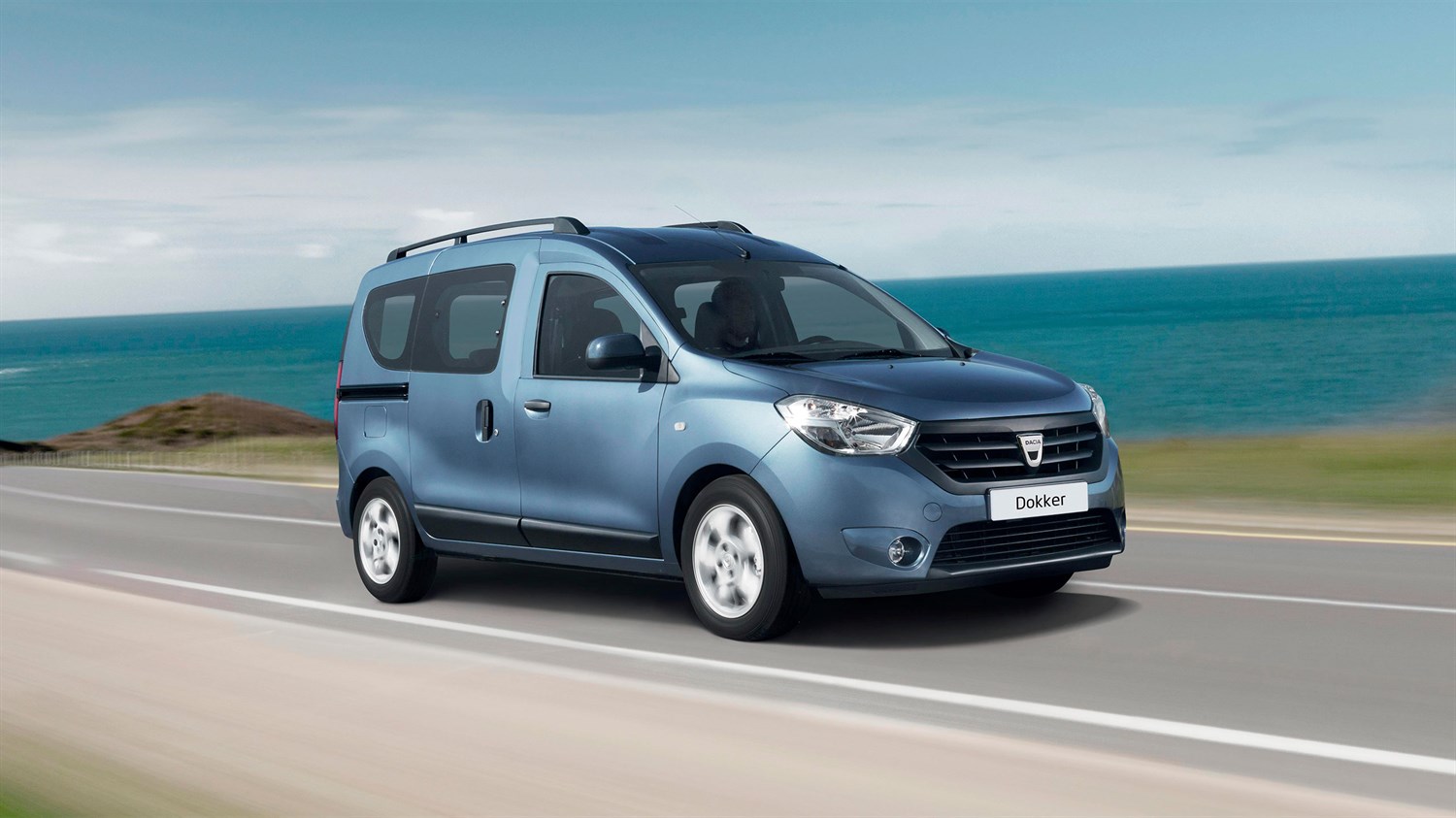 Plavi Dacia Dokker u vožnji uz obalu mora.