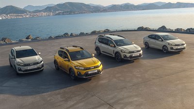 Četiri Dacia vozila parkirana uz obalu, s planinama i morem u pozadini.