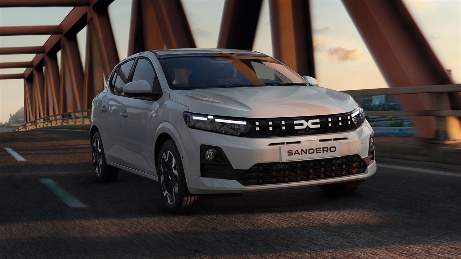 Bijeli Dacia Sandero u vožnji preko mosta.
