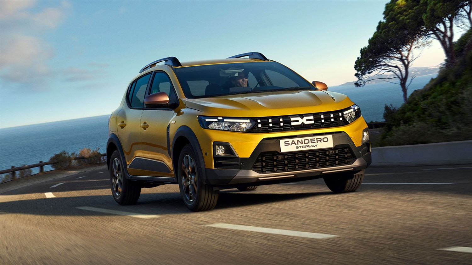 Žuti Dacia Sandero Stepway u vožnji obalnom cestom.