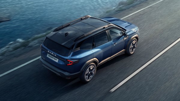 Tamnoplavi Dacia Bigster u vožnji autocestom uz obalu