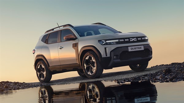 Dacia Duster na kamenitoj obali uz more u suton