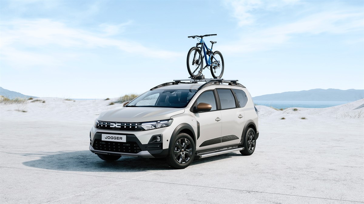 Vozilo Dacia Jogger na otvorenom prostoru s biciklom pričvršćenim na krovne nosače.