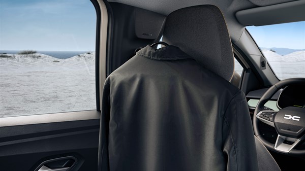 Kaput obješen na YouClip vješalicu postavljenu na naslon sjedala u vozilu Dacia Jogger.