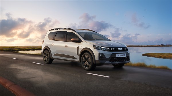 Vozilo Dacia Jogger straga u vožnji gradskom cestom uz moderne zgrade.








