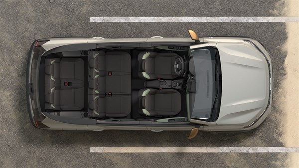 Pogled odozgo na vozilo Dacia Jogger parkirano na označenom parkirnom mjestu, s jasno vidljivim sjedalima i putničkim prostorom.