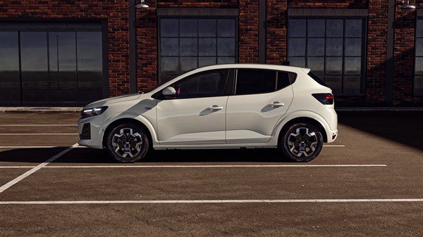 Vozilo Dacia Sandero snimljeno sa strane na parkiralištu, s redizajniranom prednjom maskom i pixel efektom svjetlosnog potpisa.