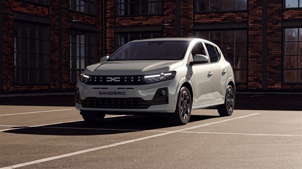 Vozilo Dacia Sandero snimljeno sprijeda na parkiralištu, s redizajniranom prednjom maskom i pixel efektom svjetlosnog potpisa.