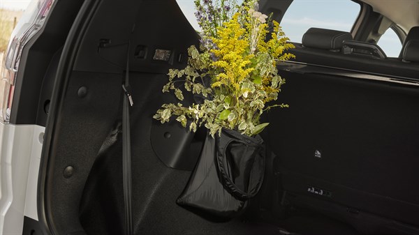 YouClip preklopna torba pričvršćena u prtljažniku vozila Dacia Sandero Stepway, napunjena grančicama cvijeća.