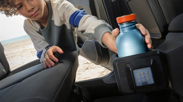 Dijete umeće bocu u YouClip držač za boce pričvršćen na stražnju stranu sjedala u vozilu Dacia Sandero Stepway.