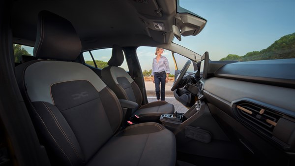 Unutrašnjost vozila Dacia Sandero s perivim Microcloud presvlakama i povišenim položajem vožnje, snimljena sprijeda prema putničkom prostoru.