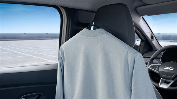 Siva majica visi na YouClip vješalici pričvršćenoj iza prednjeg sjedala u unutrašnjosti vozila Dacia.
