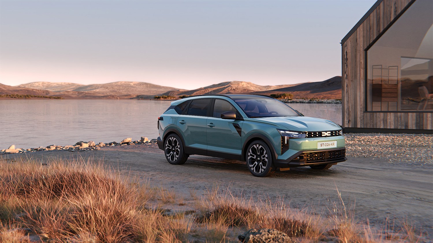 Dacia Striker prikazan uz obalu jezera i moderan objekt, s planinskim krajolikom u pozadini.