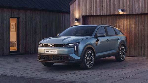 Vozilo Dacia Striker prikazano sprijeda ispred modernog objekta, s naglašenim robusnim dizajnom i aerodinamičnom siluetom.