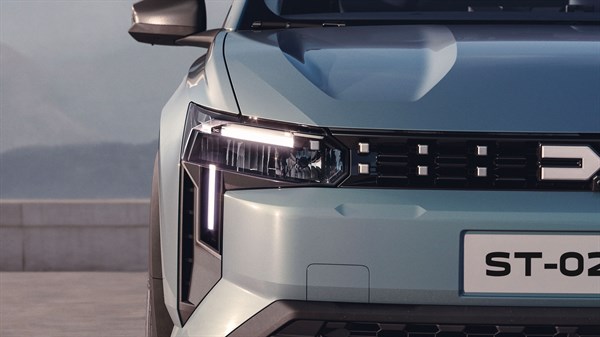 Detaljan prikaz prednjeg dijela vozila Dacia Striker s istaknutim svjetlosnim potpisom i maskom vozila.