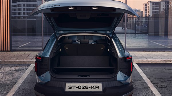 Stražnji prikaz vozila Dacia Striker s električno otvorenim prtljažnikom i prikazom prostranog prtljažnog prostora.
