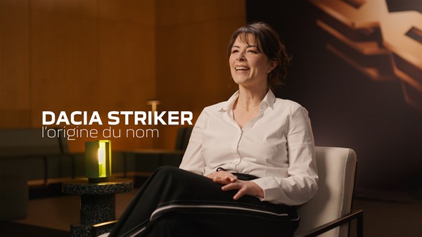 žena sjedi u modernom interijeru tijekom razgovora o modelu Dacia Striker, uz natpis Dacia Striker l’origine du nom na ekranu koji najavljuje priču o podrijetlu naziva vozila