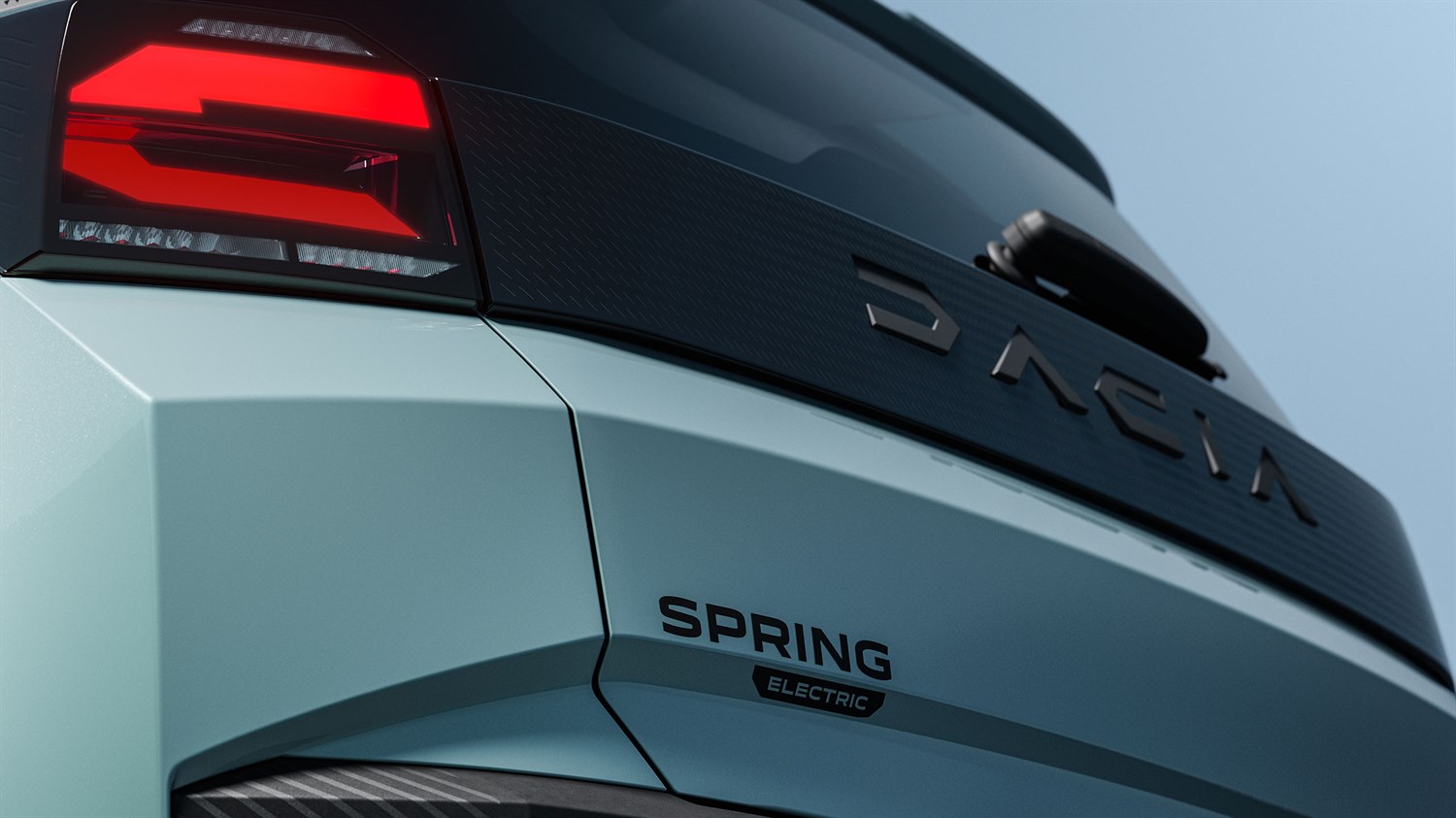 Stražnji dio vozila Dacia Spring s vidljivim oznakama Dacia i Spring electric na svijetloplavoj karoseriji.