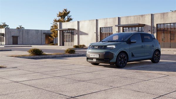Vozilo Dacia Spring parkirano ispred moderne zgrade.