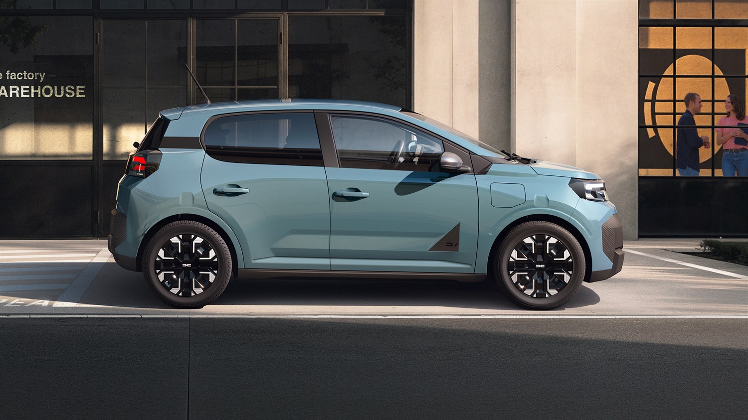 Bočni profil vozila Dacia Spring u Agave boji na gradskoj ulici.