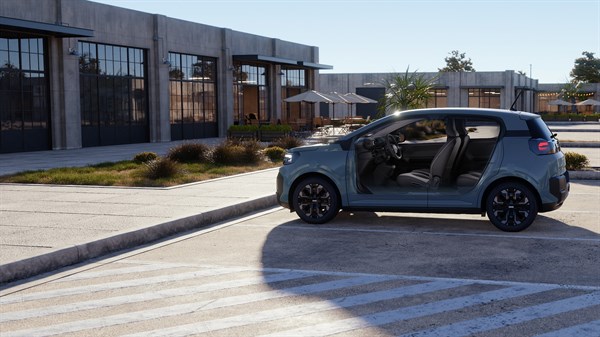 Vozilo Dacia Spring s otvorenim vratima na gradskoj ulici.