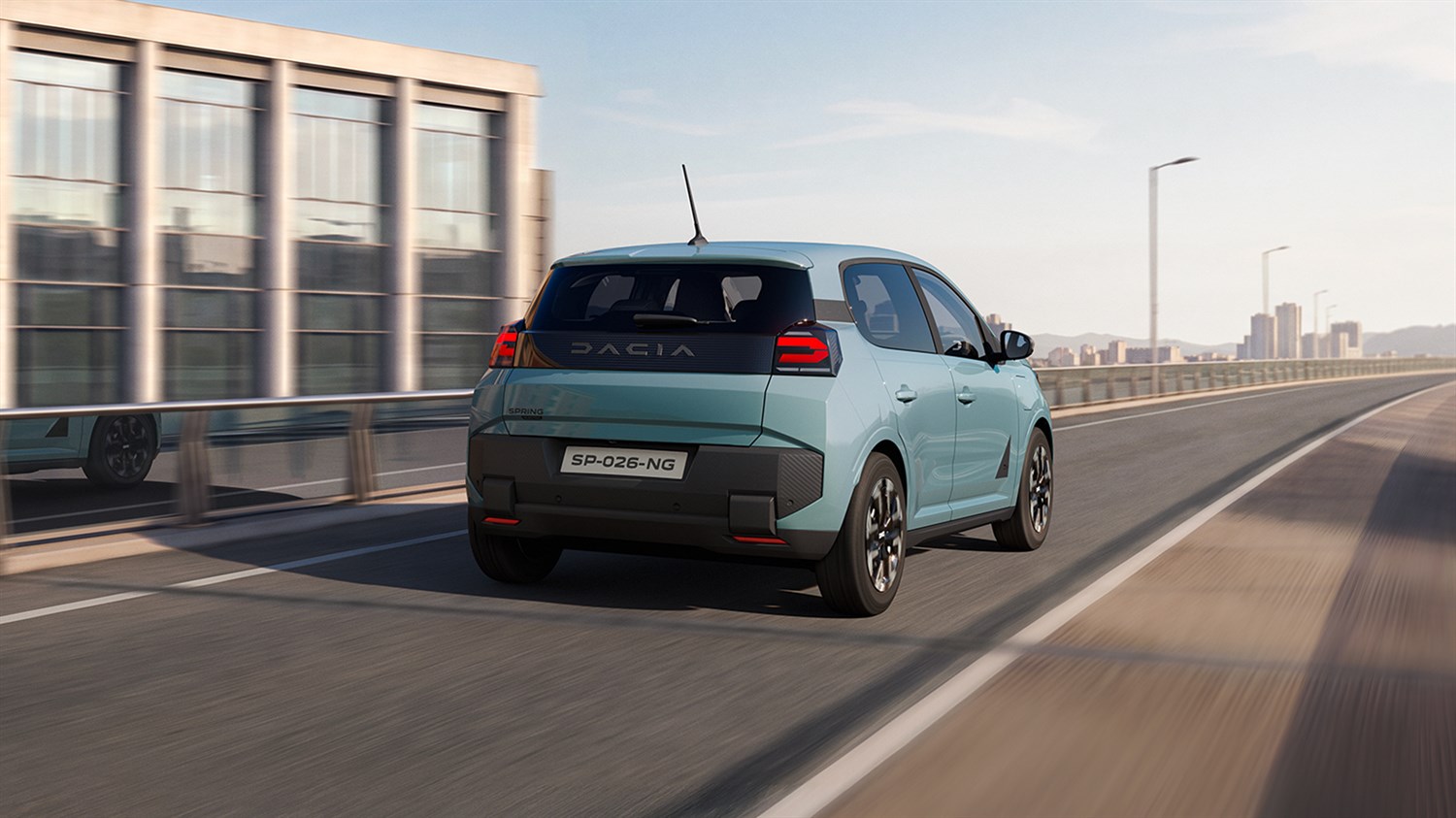 Vozilo Dacia Spring u vožnji gradskom prometnicom, pogled straga.
