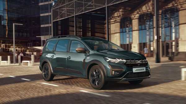 Vozilo Dacia Jogger ispred modernog poslovnog objekta.