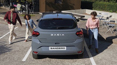 Vozilo Dacia Sandero ECO-G parkirano na otvorenom, prikazano straga, s ljudima u blizini


