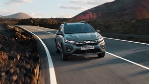 Vozilo Dacia Sandero Stepway u vožnji zavojitom cestom kroz pustinjski krajolik.